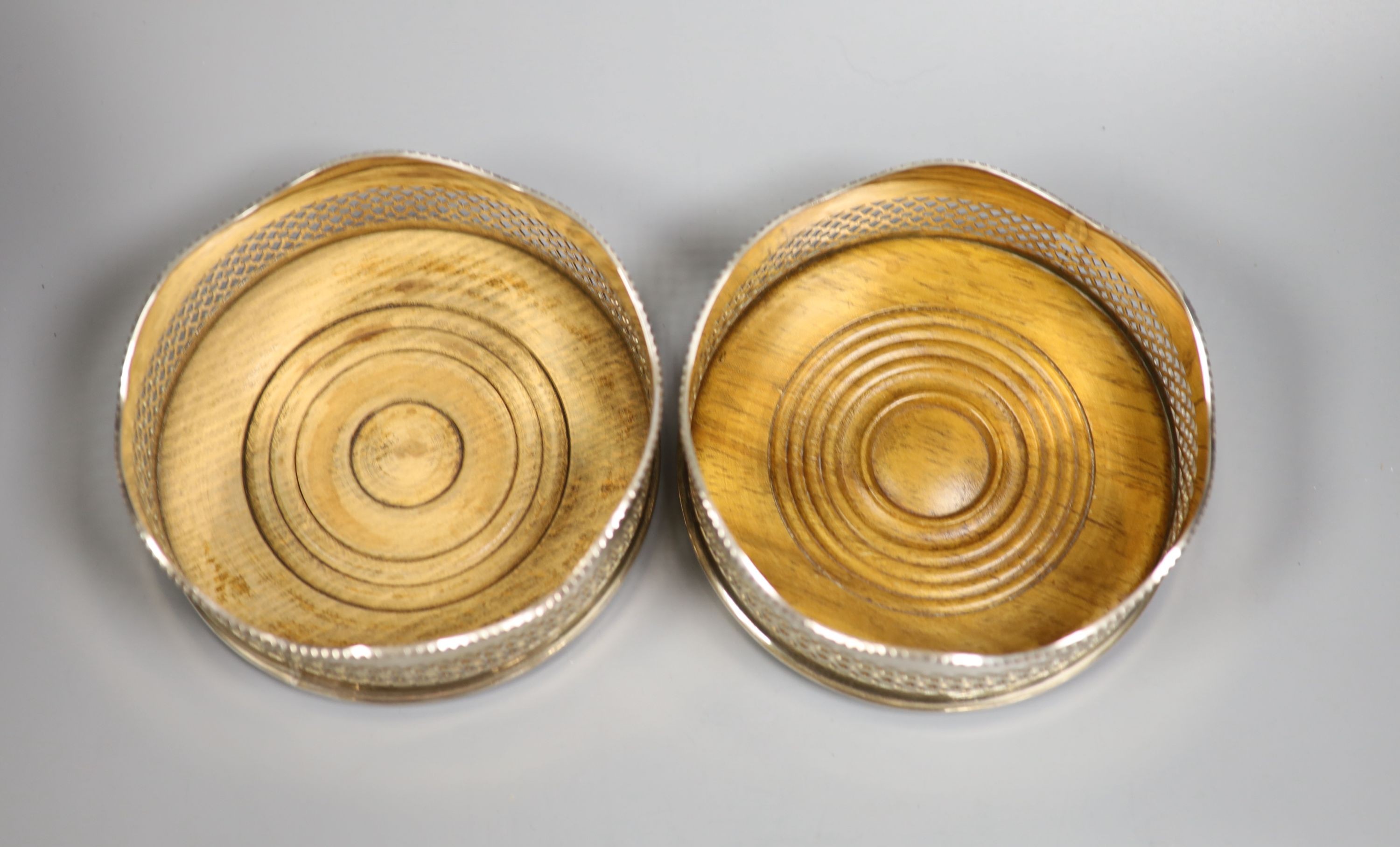 A pair of modern silver wine coasters, with wavy rims and fretwork sides, Birmingham, 1974/5, diameter 13.5cm.